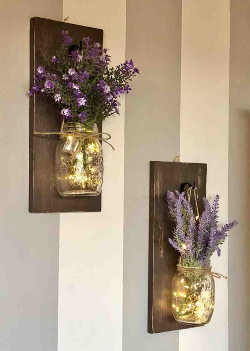 barattoli con fiori e luci led appesi alla parete