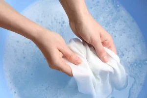 donna rimuove macchia di candeggina su vestito