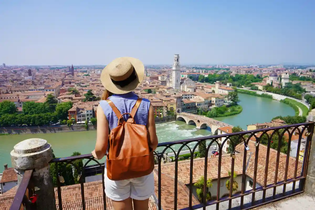 donna su balconata esplora il panorama della città di Verona